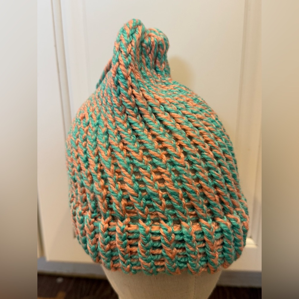 Beanie hat in a teal and pink braided knit pattern